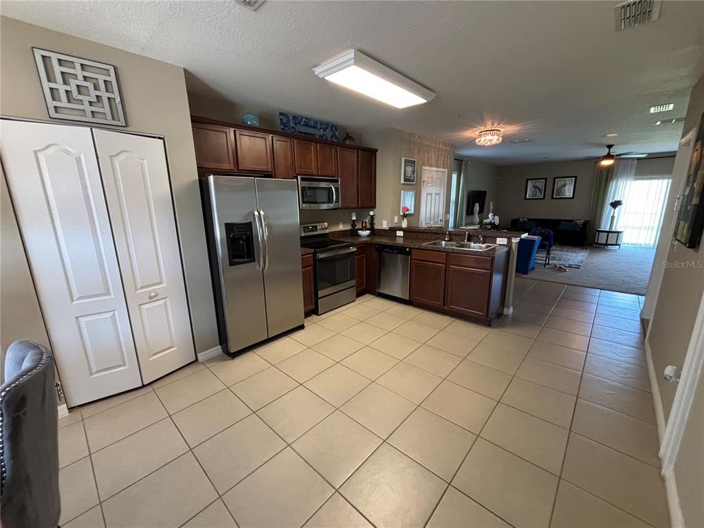 A kitchen with dark wood cabinets, stainless steel appliances, and a mobile island — 1861 CHATHAM PLACE DRIVE, ORLANDO, FL