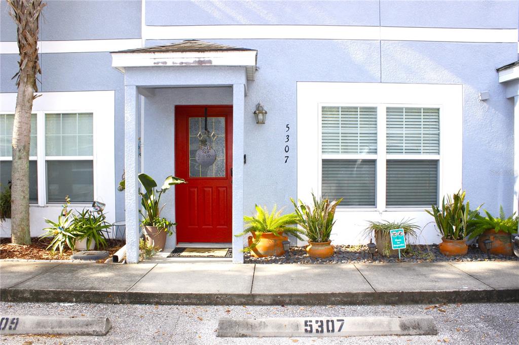 A living room entryway features a white door, a side table, and wall decor — 5307 TERRAZA COURT, TEMPLE TERRACE, FL