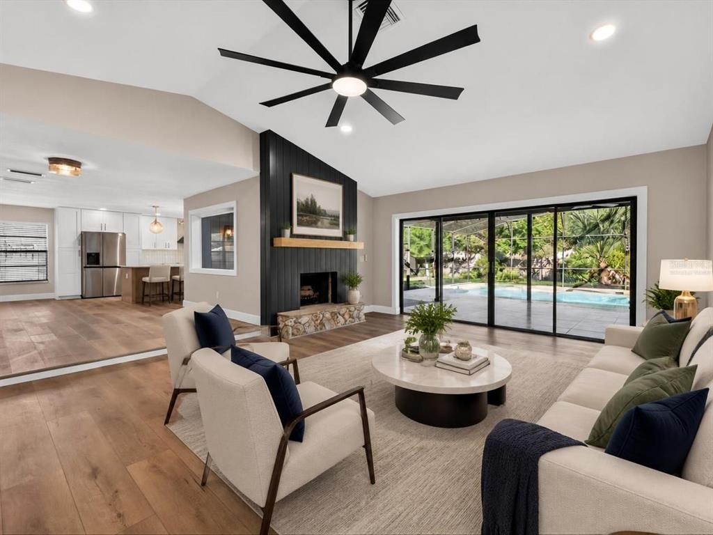 A living room features a black fireplace, a large ceiling fan, and sliding glass doors — 2183 BENT OAK DRIVE, APOPKA, FL