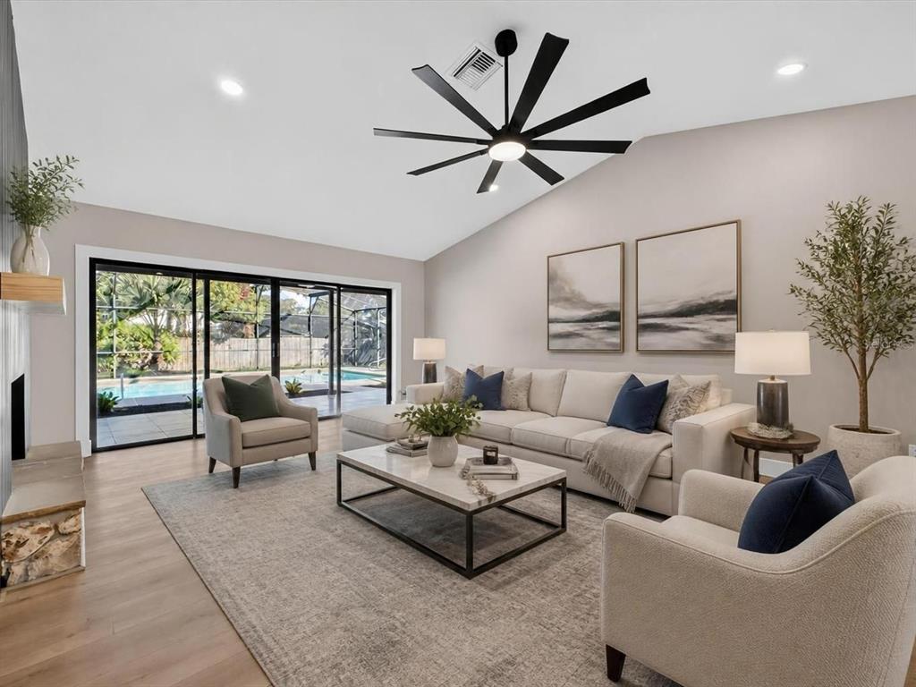 A living room features a vaulted ceiling, a large sectional sofa, and sliding glass doors — 2183 BENT OAK DRIVE, APOPKA, FL