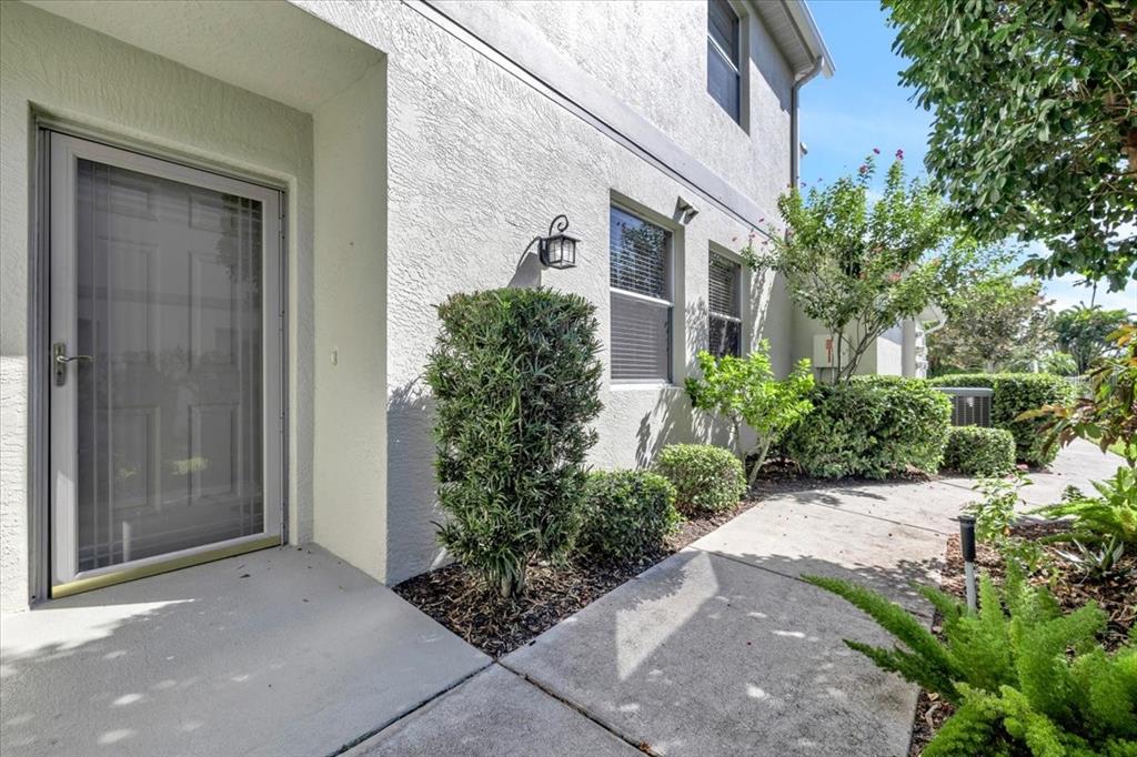 A concrete walkway leads to the front entrance of a light-colored stucco home — 3303 GRAND VISTA COURT UNIT 101, PORT CHARLOTTE, FL