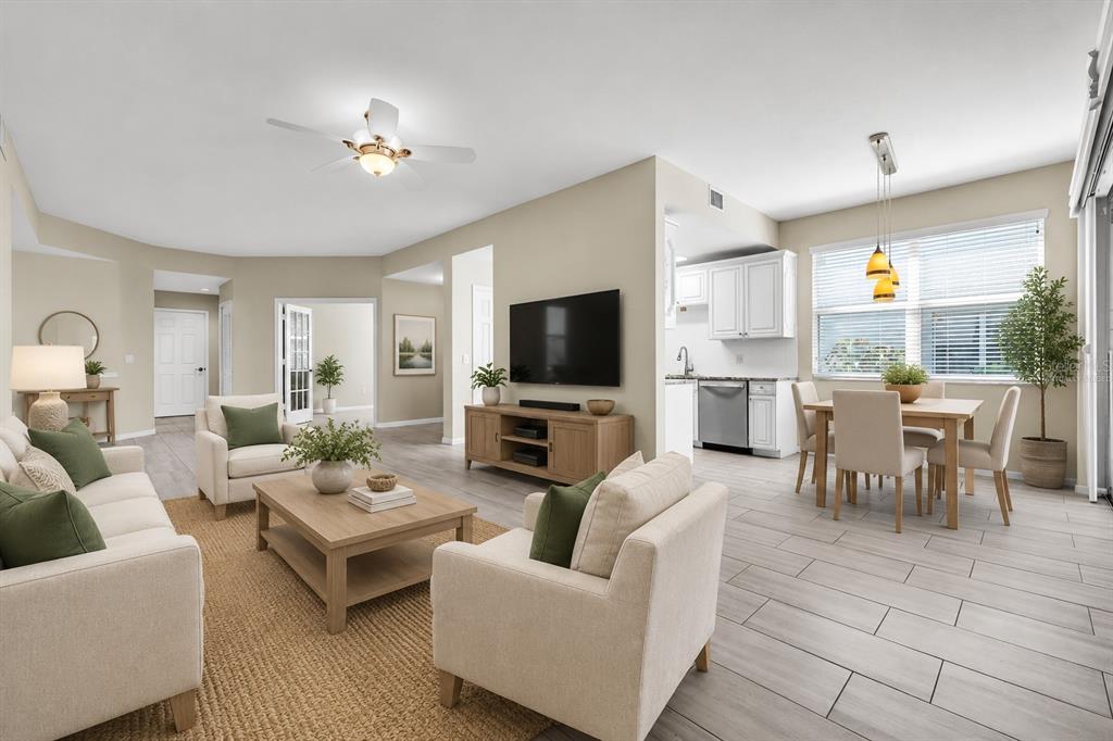 An open-concept living and dining area features light tile flooring, neutral furniture, and white cabinetry — 3303 GRAND VISTA COURT UNIT 101, PORT CHARLOTTE, FL