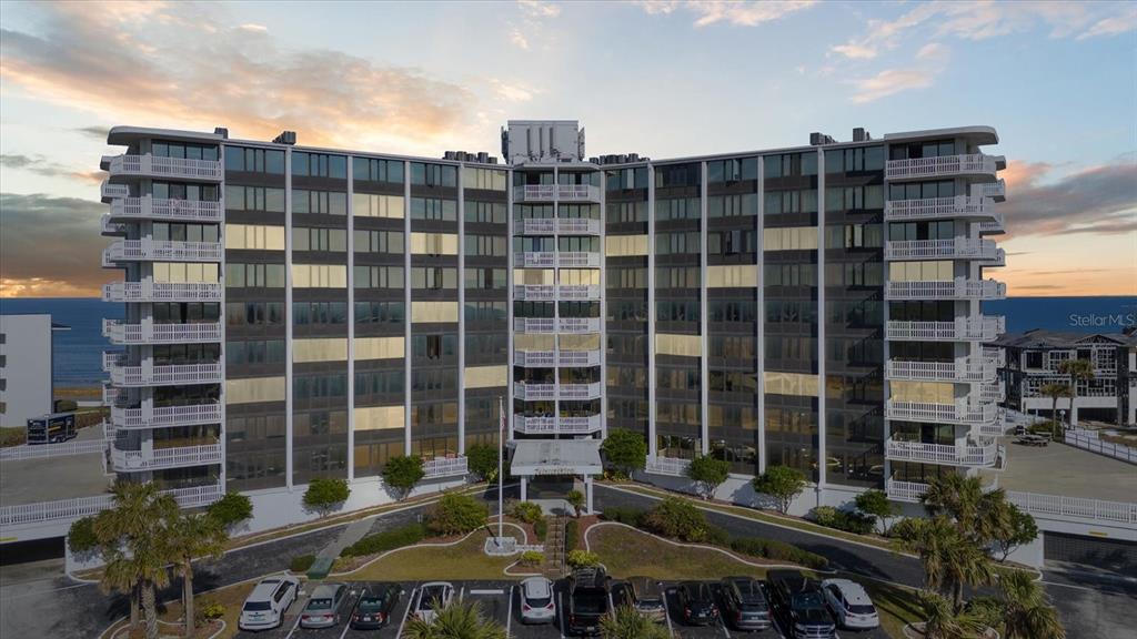 An aerial view of a multi-story beachfront condominium building with a parking lot in front — 3580 S OCEAN SHORE BOULEVARD UNIT 101, FLAGLER BEACH, FL