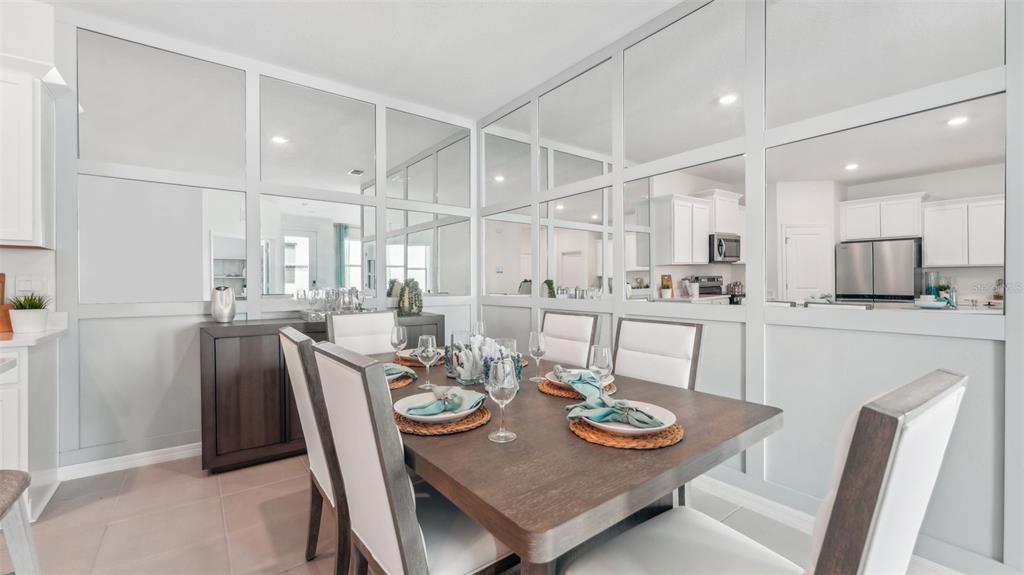 A dining room features a wooden table, white chairs, and a wall of decorative mirrors — 33018 RUSTIC RISE ROAD, SAN ANTONIO, FL