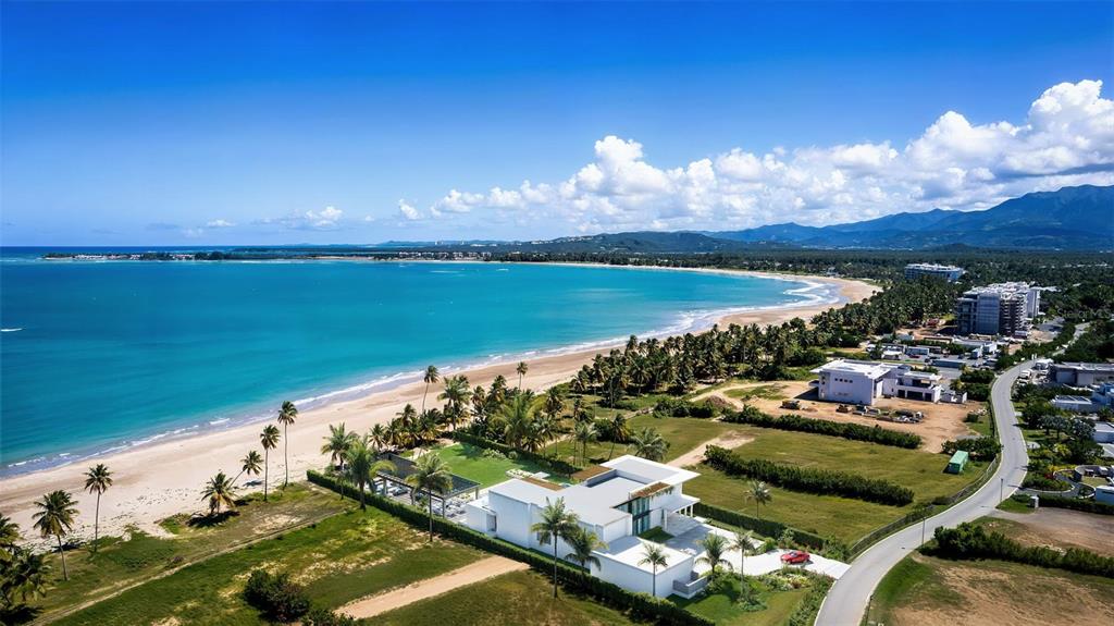 An aerial view shows a modern white house situated on a sandy beach — Atlantic Drive BEACHFRONT LOT ATLANTIC DRIVE AT THE FOUR SEASONS Lot 12, RIO GRANDE, PR