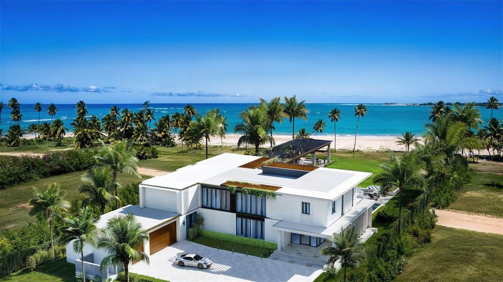 This is a rendering of a modern two-story villa with a car parked outside — Atlantic Drive BEACHFRONT LOT ATLANTIC DRIVE AT THE FOUR SEASONS Lot 12, RIO GRANDE, PR