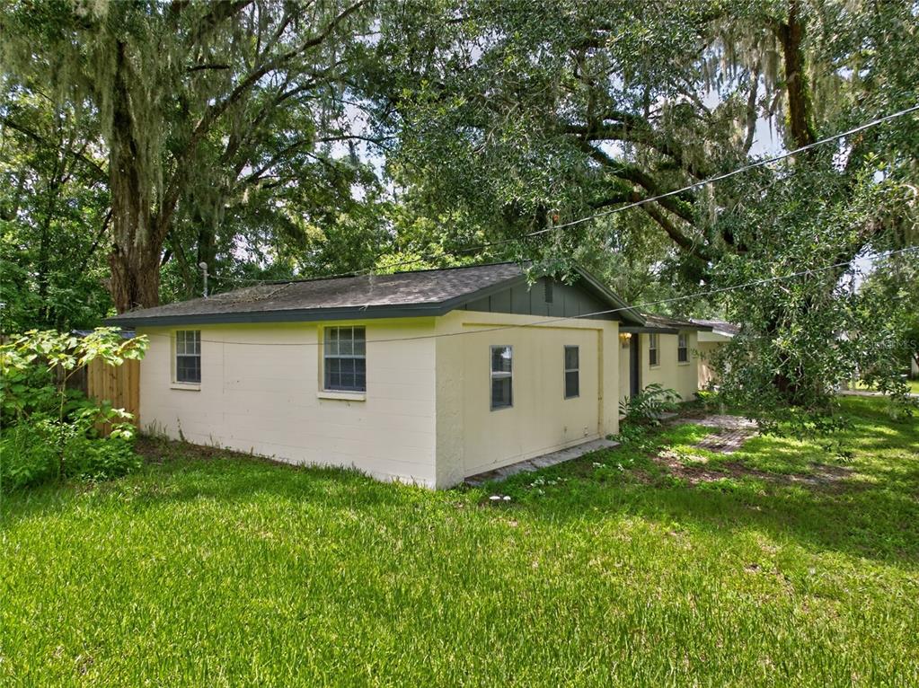 A room with light-colored walls, wood-look flooring, a ceiling fan, and white bi-fold closet doors — 26356 ROLLING ACRES DRIVE, BROOKSVILLE, FL