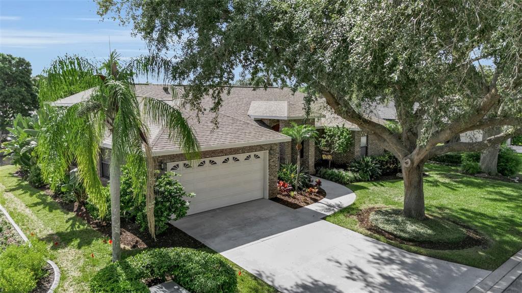 An aerial view of a brick house with a two-car garage and mature trees — 4739 SPRING MEADOW LANE, SARASOTA, FL