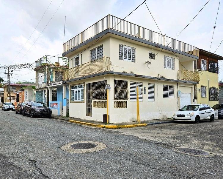 A two-story corner building with a rooftop terrace and metal security bars on the windows — 115 COMM PARIS 115, ESQUINA DE LA CRUZ ROJA CALLE DR., MAYAGUEZ, PR