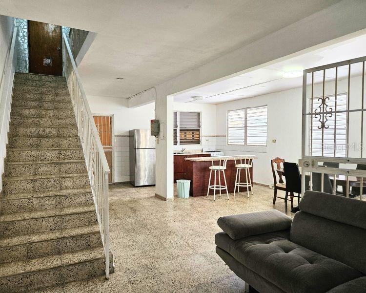 An interior view shows a staircase, a kitchen with a breakfast bar, and a living area — 115 COMM PARIS 115, ESQUINA DE LA CRUZ ROJA CALLE DR., MAYAGUEZ, PR