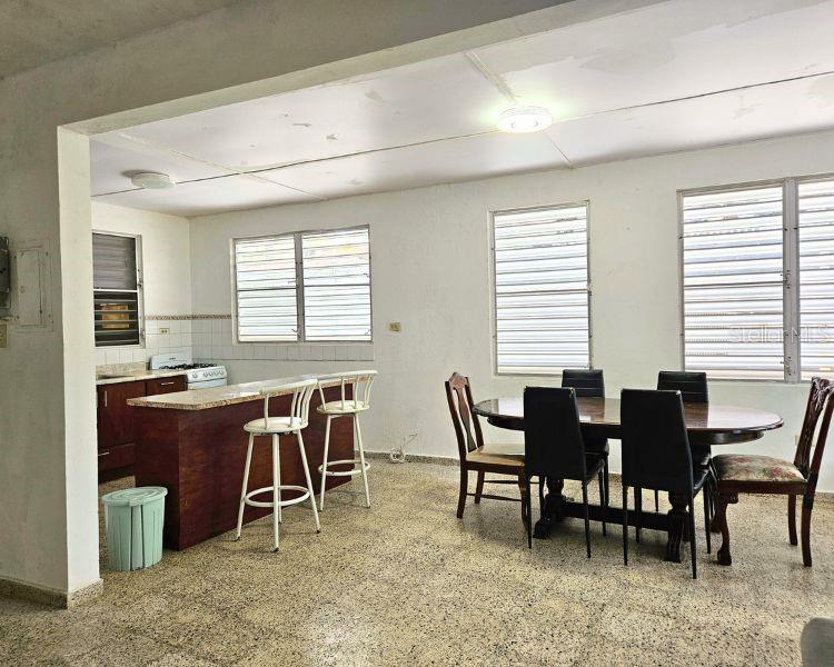 A kitchen with a wooden island and a dining area with a table and chairs — 115 COMM PARIS 115, ESQUINA DE LA CRUZ ROJA CALLE DR., MAYAGUEZ, PR
