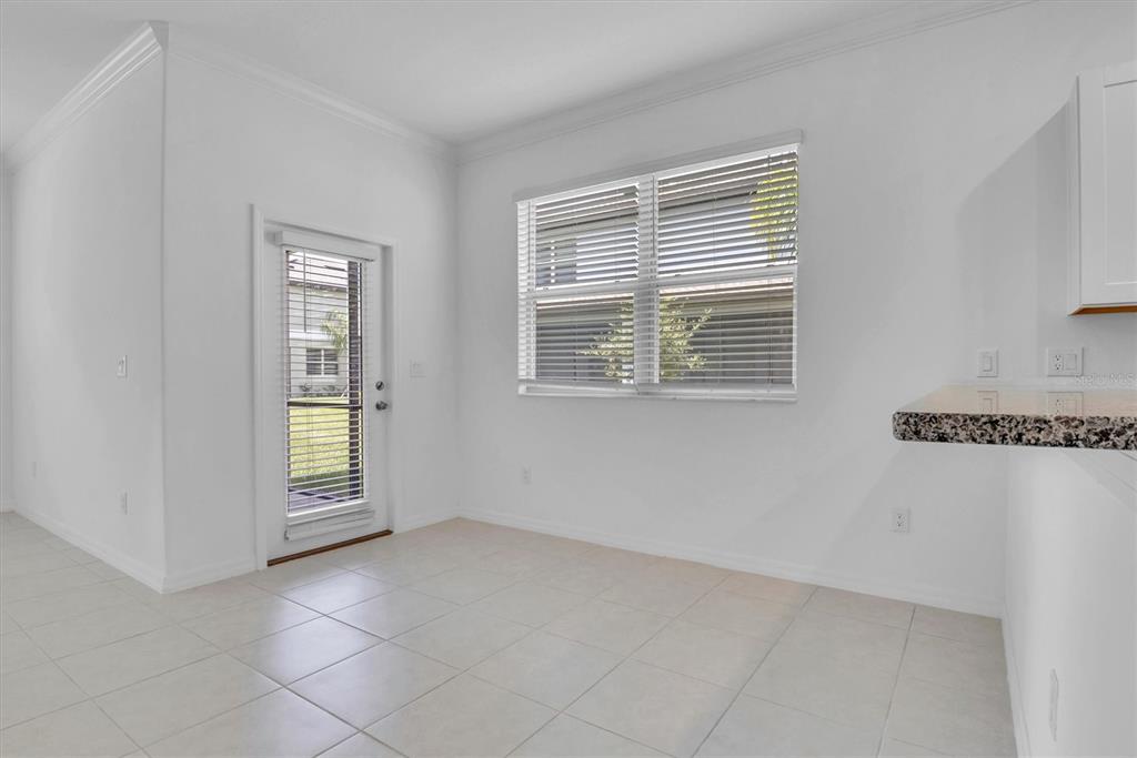 A bright, empty room with white walls, tile flooring, a glass door, and a window — 30687 VERIDIAN WAY, WESLEY CHAPEL, FL