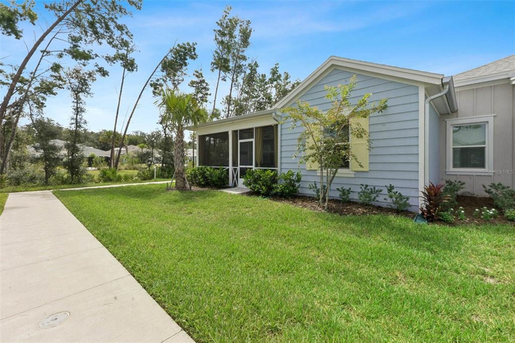 A light blue house with a screened-in porch, yellow shutters, and a concrete walkway — 384 GYPSY PALACE LANE, DAYTONA BEACH, FL