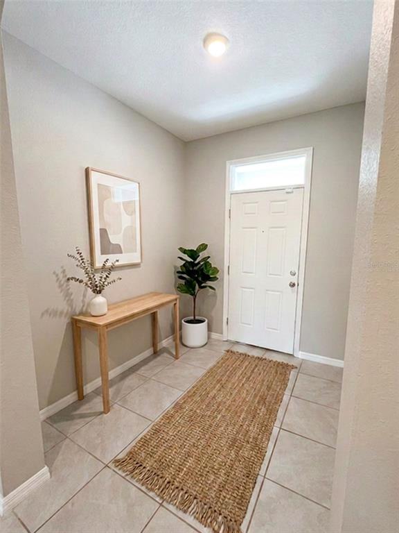 A carpeted hallway leads to a bedroom with a window and gray walls — 5254 DRAGONFLY DRIVE, WILDWOOD, FL