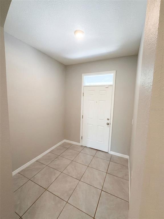 An open-concept kitchen features dark cabinets, granite countertops, and light-colored tile flooring — 5254 DRAGONFLY DRIVE, WILDWOOD, FL