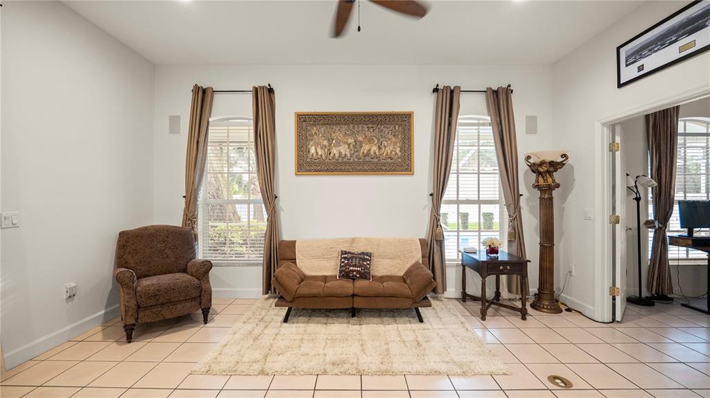A living room features tile floors, a brown sofa, an armchair, and two windows — 318 HAMILTON SHORES DRIVE NE, WINTER HAVEN, FL