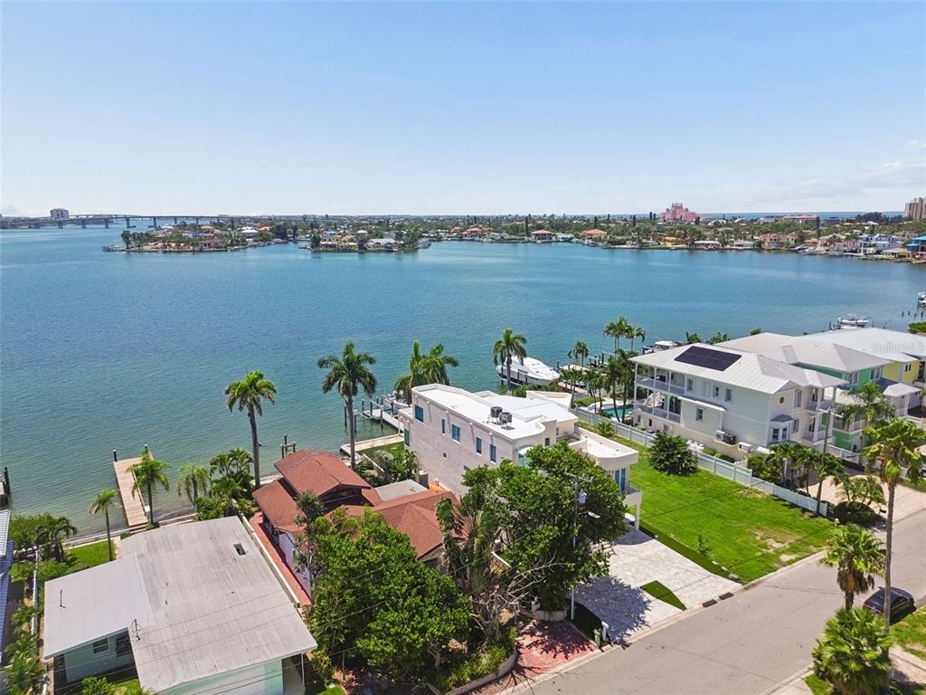 An aerial view shows waterfront houses with docks, palm trees, and a large bay — 720 BOCA CIEGA ISLE DRIVE, ST PETE BEACH, FL
