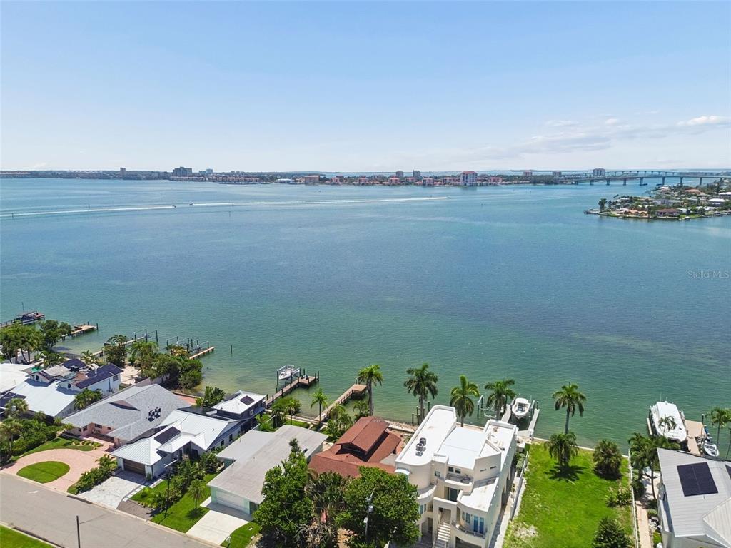 An aerial view of waterfront homes with private docks along a bay under a clear sky — 720 BOCA CIEGA ISLE DRIVE, ST PETE BEACH, FL