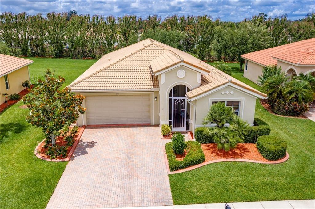 An aerial view of a single-story house with a tan exterior, tile roof, and driveway — 3189 ASTOR AVENUE, VERO BEACH, FL