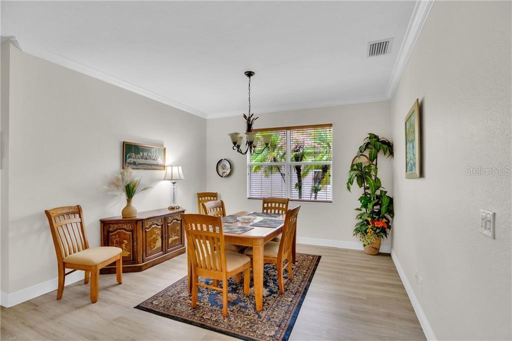 A dining room features a wooden table and chairs, a sideboard, and a patterned area rug — 3189 ASTOR AVENUE, VERO BEACH, FL