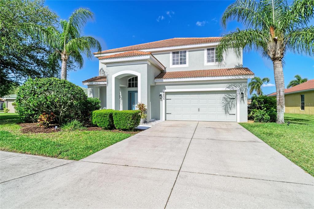 A two-story house with a light-colored exterior, a tile roof, and a two-car garage — 9035 WILLOWBROOK CIRCLE, BRADENTON, FL