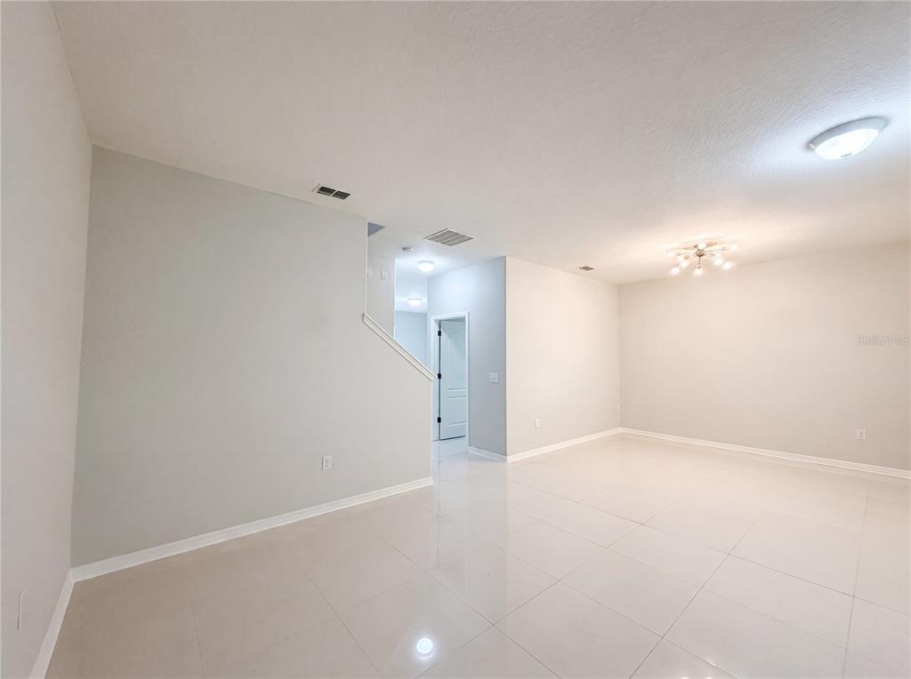 An empty room with light gray walls, white tile flooring, and a modern ceiling light — 1308 SEBURN ROAD, APOPKA, FL