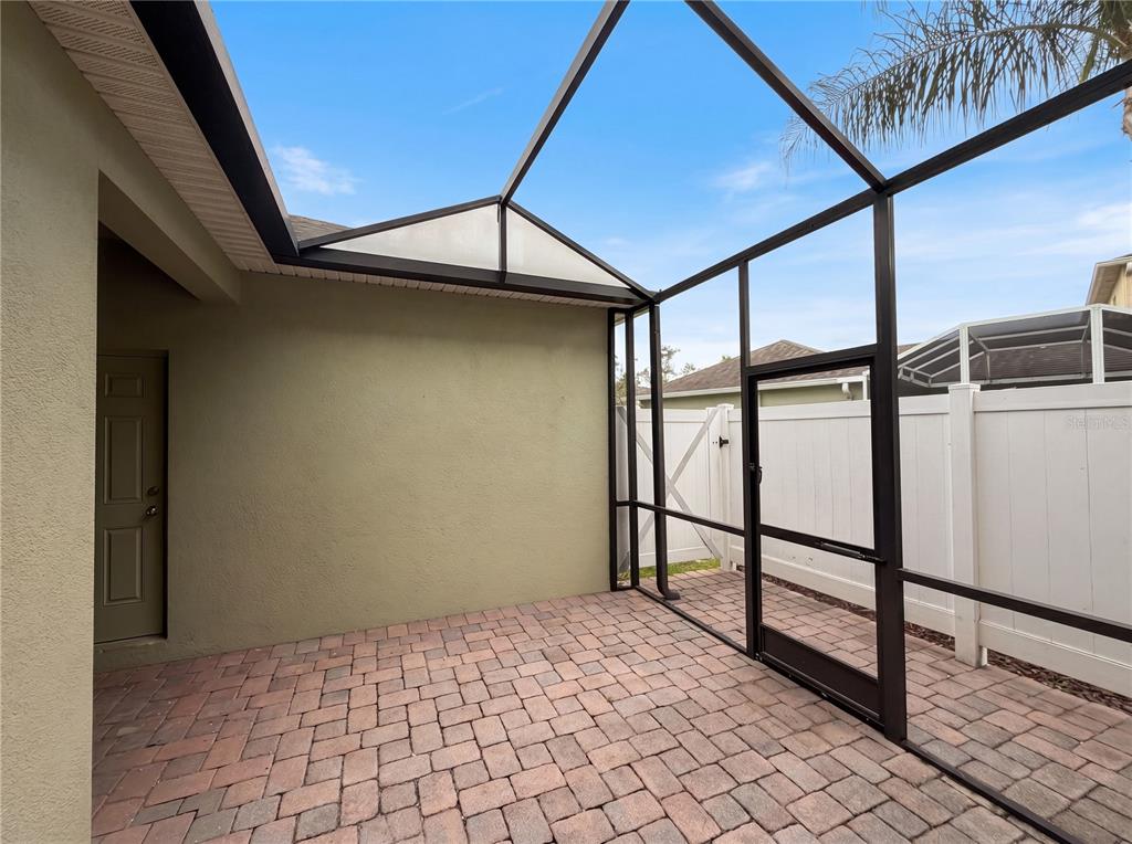 A screened-in patio features a paver floor and a door leading to the house — 1308 SEBURN ROAD, APOPKA, FL