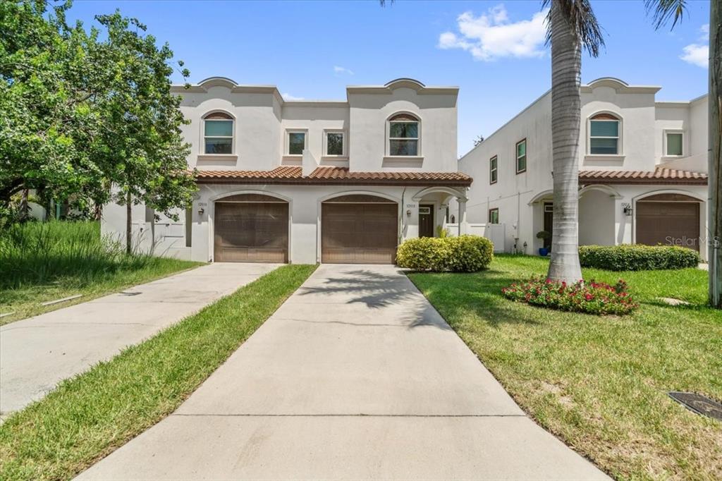 An aerial view shows a city street, residential buildings, and high-rise towers near a bay — 3203 W SANTIAGO STREET UNIT B, TAMPA, FL