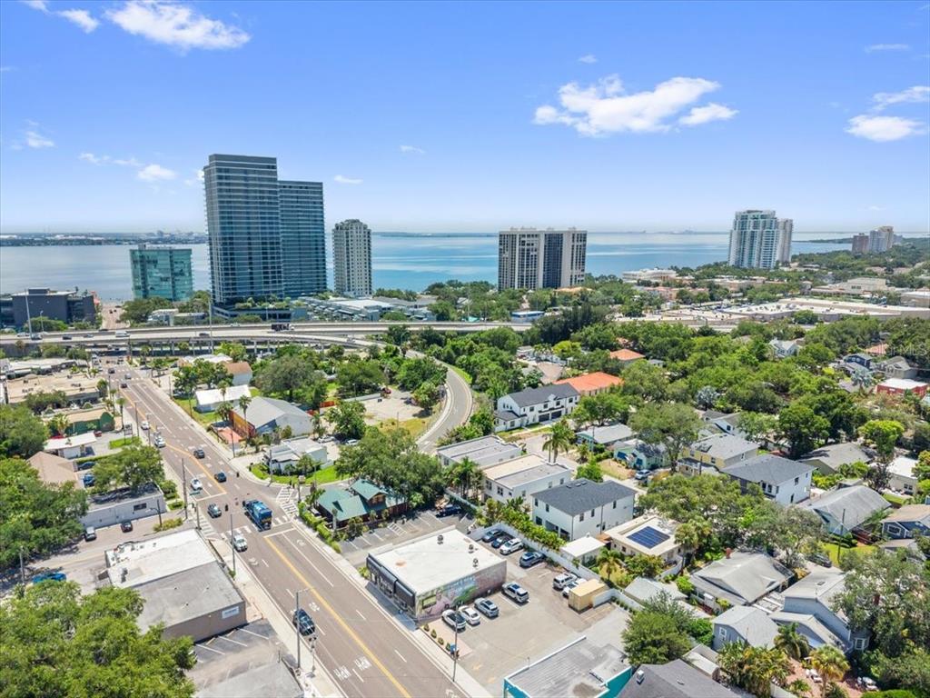 An aerial view shows a residential street with townhomes, nearby commercial buildings, and surrounding trees — 3203 W SANTIAGO STREET UNIT B, TAMPA, FL