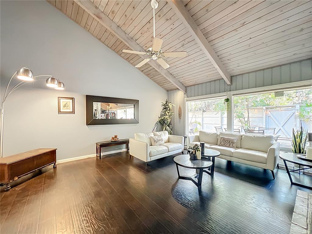 A living room features dark wood floors, a vaulted wood-paneled ceiling, and white sofas — 104 JUNIPER LANE, LONGWOOD, FL