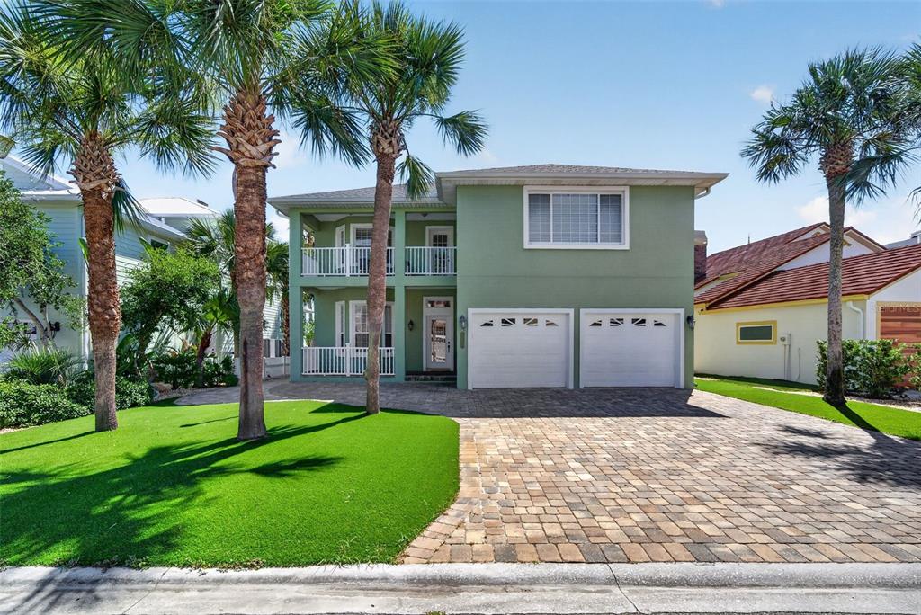 A two-story green house with a two-car garage, front balconies, and a paved driveway — 9138 JUNE LANE, ST AUGUSTINE, FL