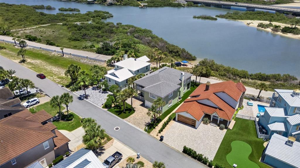 An aerial view shows several coastal houses with paved driveways near a body of water — 9138 JUNE LANE, ST AUGUSTINE, FL