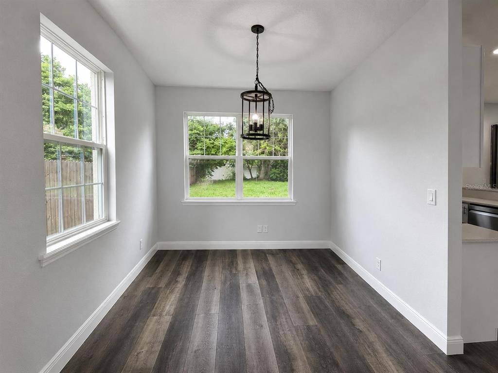 This dining room features a marble oval table, upholstered chairs, and a modern pendant light — 3778 MARTIN STREET, ORLANDO, FL