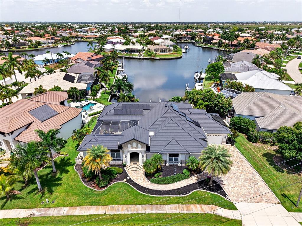 An aerial view shows a house with a dark metal roof and solar panels — 3866 TURTLE DOVE BOULEVARD, PUNTA GORDA, FL