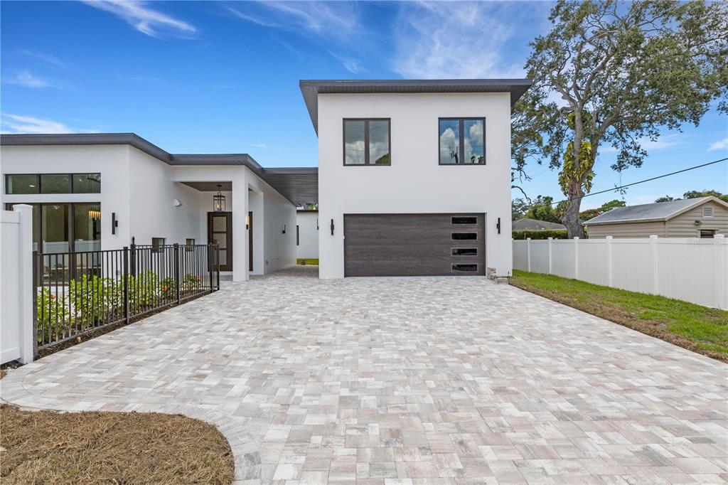 A modern two-story house features a paved driveway, a dark garage door, and white stucco walls — 2079 HIBISCUS STREET, SARASOTA, FL