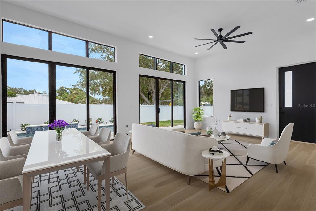 A modern living and dining room with high ceilings, large windows, and light wood flooring — 2079 HIBISCUS STREET, SARASOTA, FL