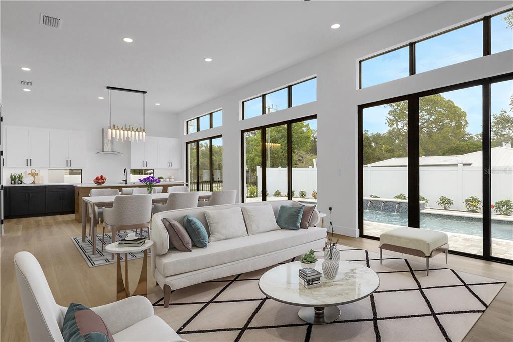 An open-concept living and dining area features white cabinetry, a pool view, and modern furniture — 2079 HIBISCUS STREET, SARASOTA, FL