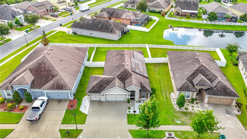 An aerial view shows three suburban houses with brown roofs and driveways in a neighborhood — 6328 SPARKLING WAY, WESLEY CHAPEL, FL
