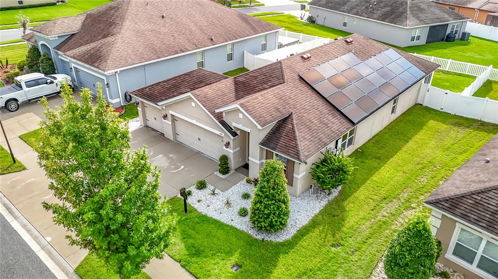 An aerial view shows a single-story house with a solar panel array on the roof — 6328 SPARKLING WAY, WESLEY CHAPEL, FL