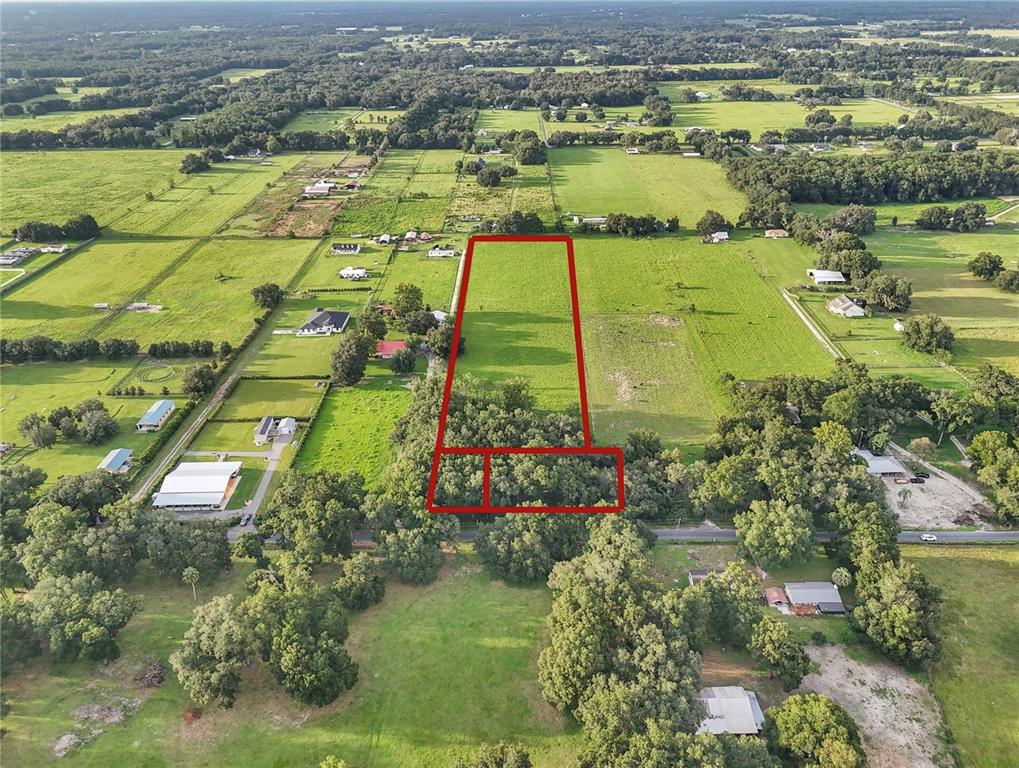 An aerial view shows a rectangular plot of land outlined in red near a road — 000 SE 160TH STREET, SUMMERFIELD, FL
