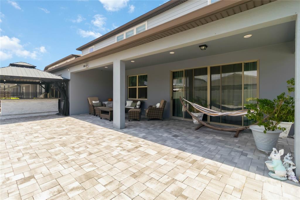 A covered patio features a paved floor, outdoor furniture, a hammock, and a gazebo — 2764 MATERA DRIVE, ST CLOUD, FL