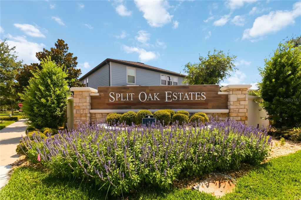A stone and wood monument sign for Split Oak Estates stands before a residential house — 2764 MATERA DRIVE, ST CLOUD, FL