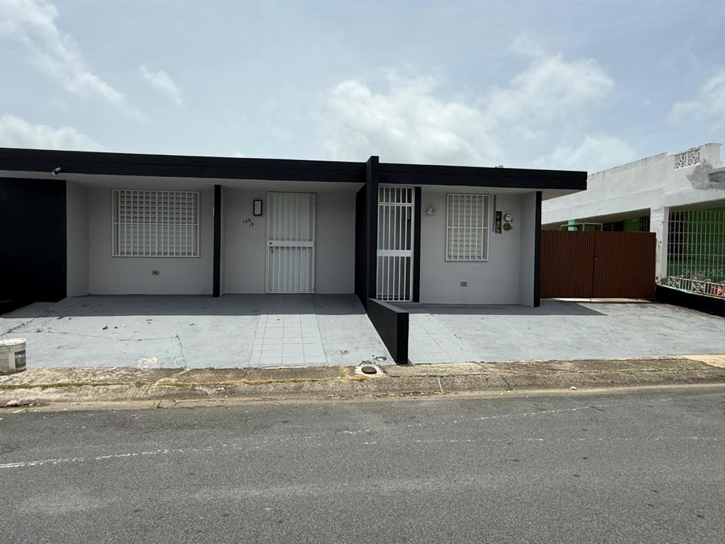 A single-story house with a flat roof, gray exterior, and two gated entryways — VILLA CAROLINA CALLE 102 UNIT 106-19, CAROLINA, PR