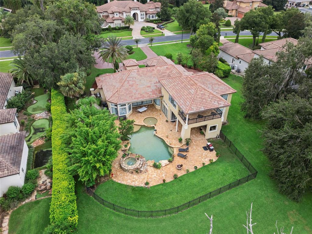 An aerial view of a two-story house with a backyard pool, spa, and putting green — 7764 ISLEWOOD COURT, SANFORD, FL