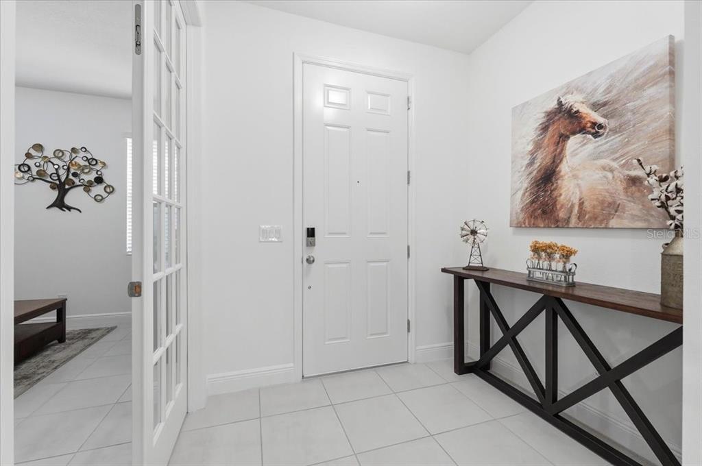 A two-story gray house with a covered front porch and a landscaped front yard — 5026 DOWN COURT, ST CLOUD, FL