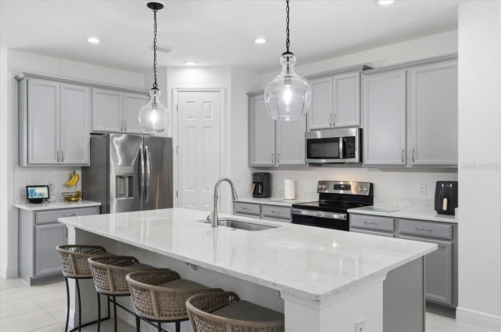 A two-story house with a gray stucco exterior, a brick driveway, and a two-car garage — 5026 DOWN COURT, ST CLOUD, FL