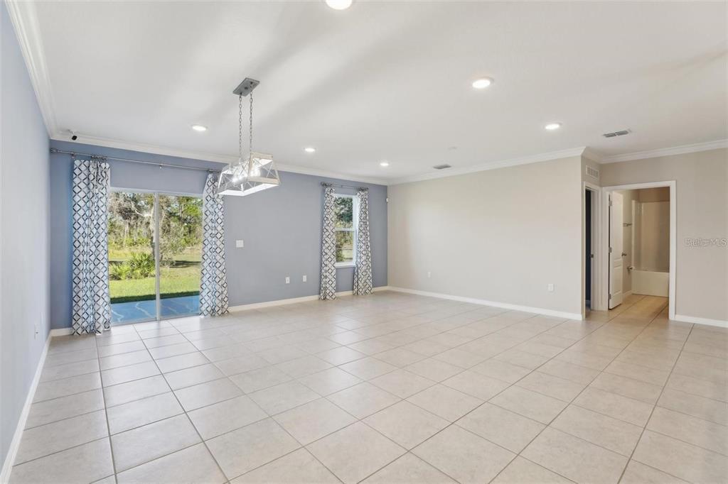 A spacious living room features light tile flooring, recessed lighting, and a sliding glass door — 2410 PARK AVENUE, INDIAN LAKE ESTATES, FL
