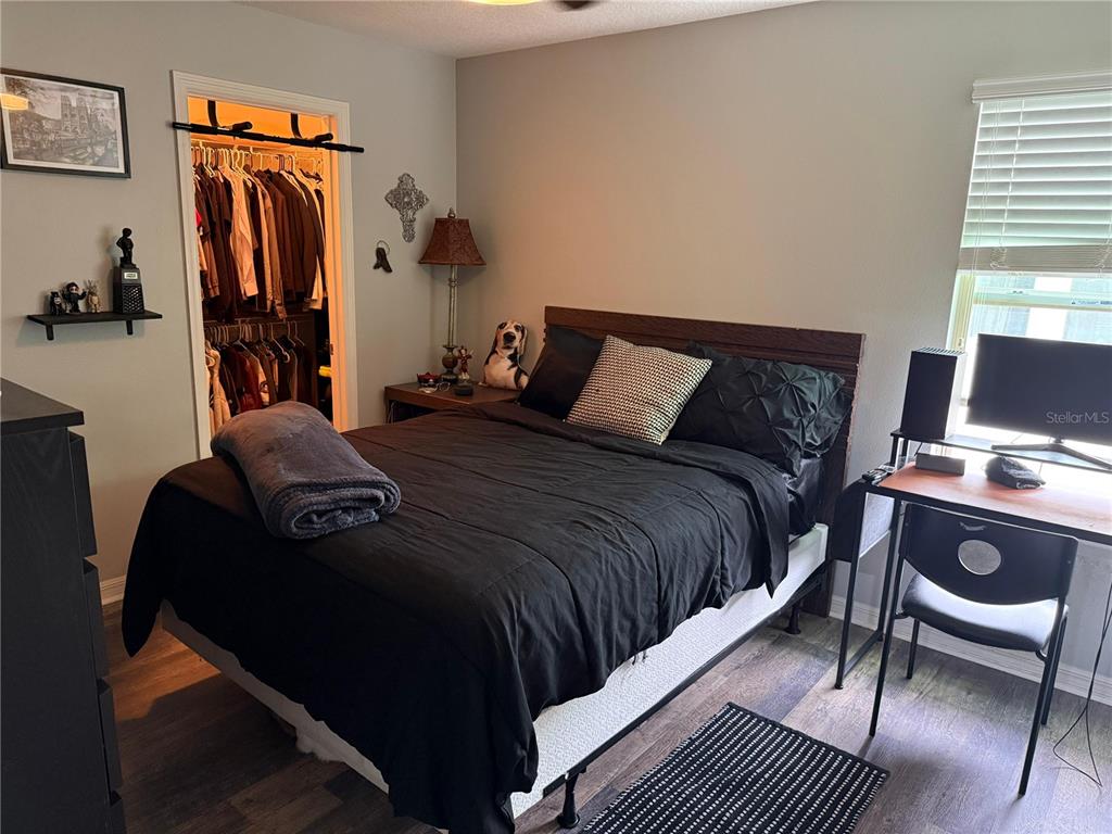 A bedroom features a bed with black bedding, a desk, and a walk-in closet — 9150 OUTLOOK ROCK TRAIL, WINDERMERE, FL