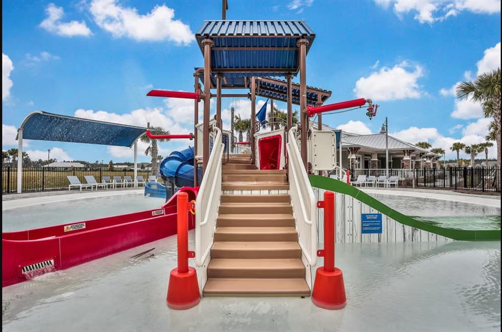 A playground structure with slides and stairs sits in a shallow swimming pool outdoors — 162 FERN VALLEY COURT, ST AUGUSTINE, FL