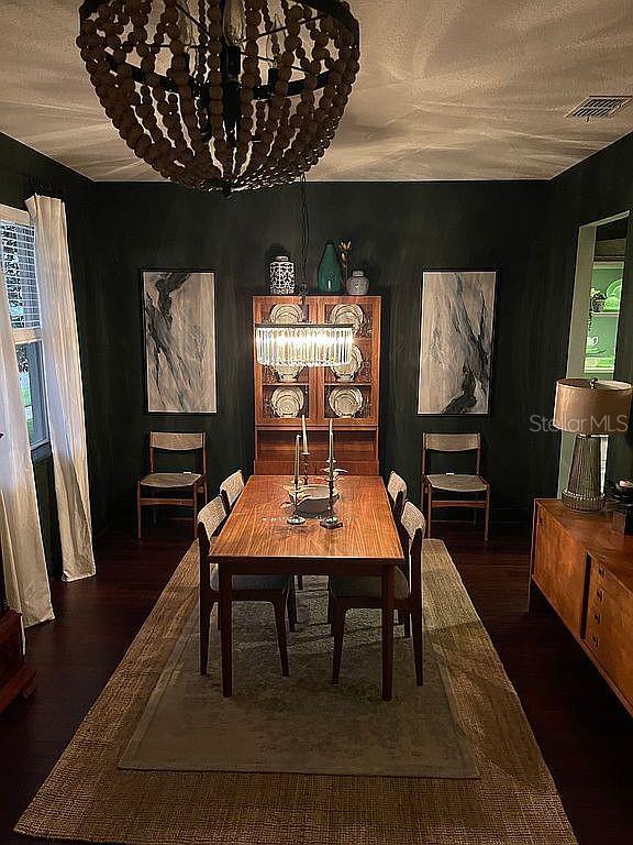 A dining room features dark walls, a wood table, a beaded chandelier, and a china cabinet — 960 SEBURN ROAD, APOPKA, FL